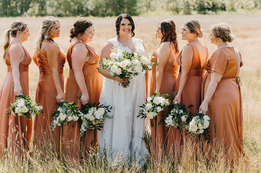 Bride and bridal party photo, bridesmaids are wearing matching terracotta bridesmaid dresses