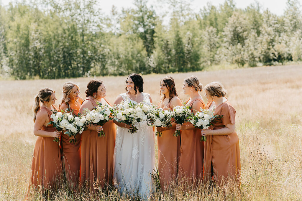 Bride and bridal party photo, bridesmaids are wearing matching terracotta bridesmaid dresses