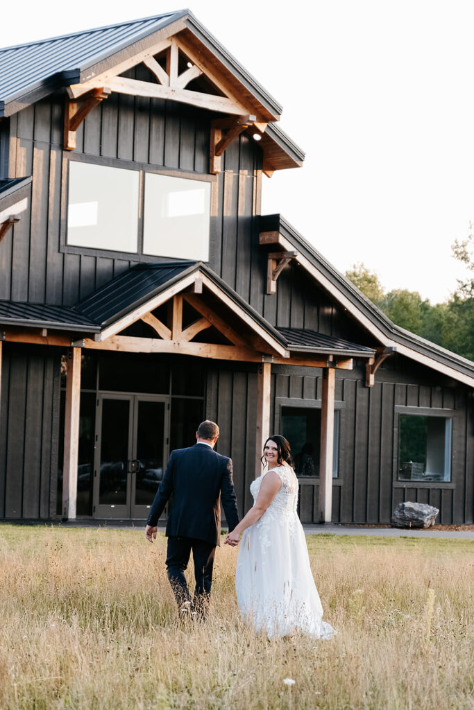 bride and groom posing in front of their Northern Minnesota wedding venue, Ivy Black
