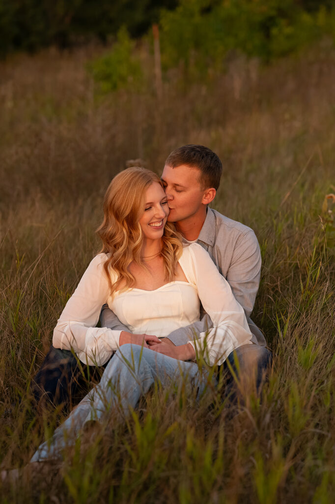 playful future bride and groom nature engagement photos in a golden field in bemidji