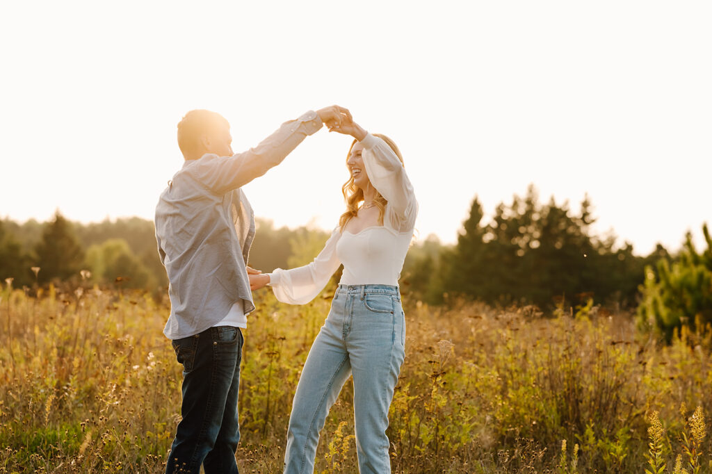 playful future bride and groom nature engagement photos in a golden field in bemidji