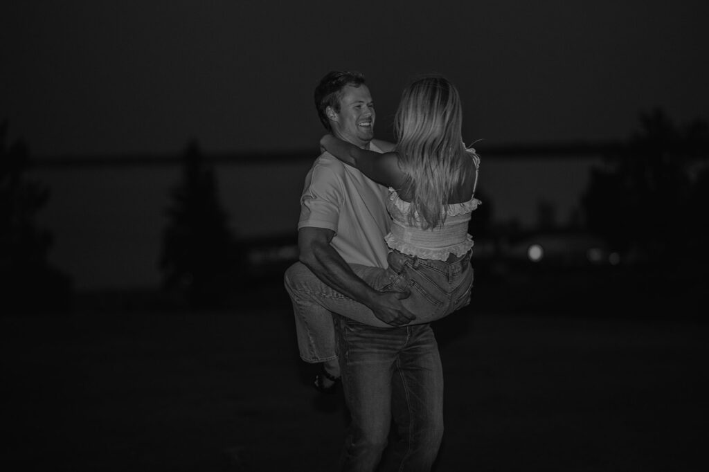 black and white playful nighttime engagement photo