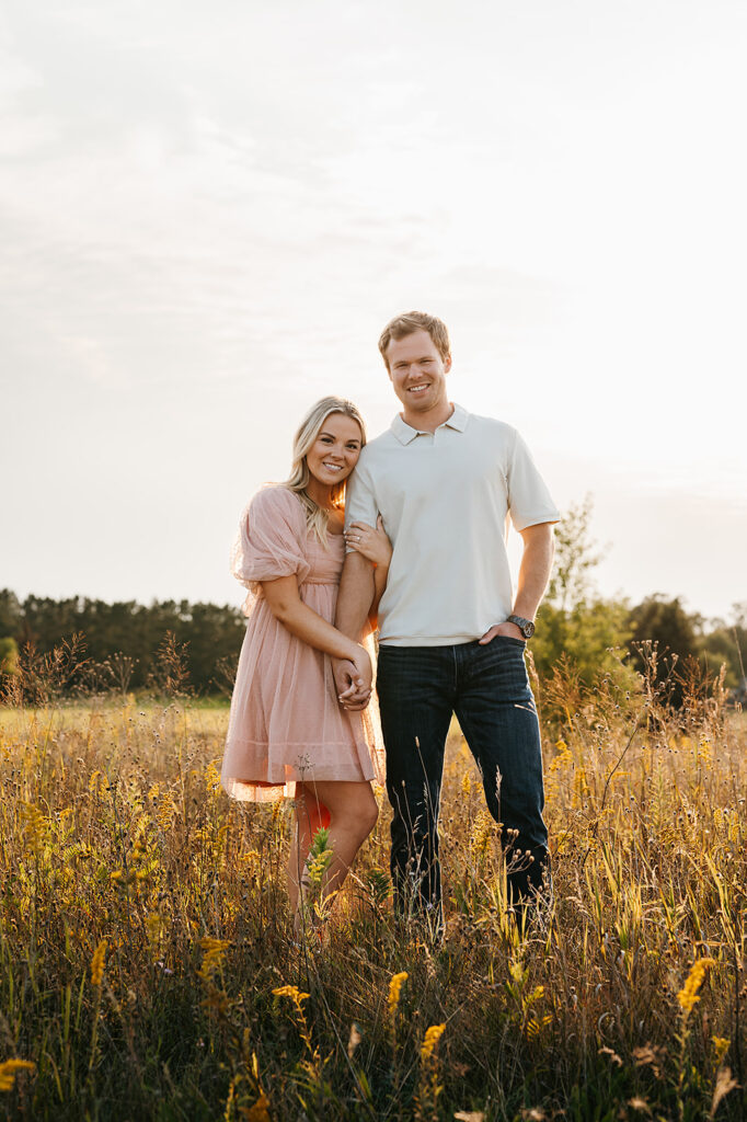 Happy couple posing in a sunlit field in Bemidji during their field engagement photos