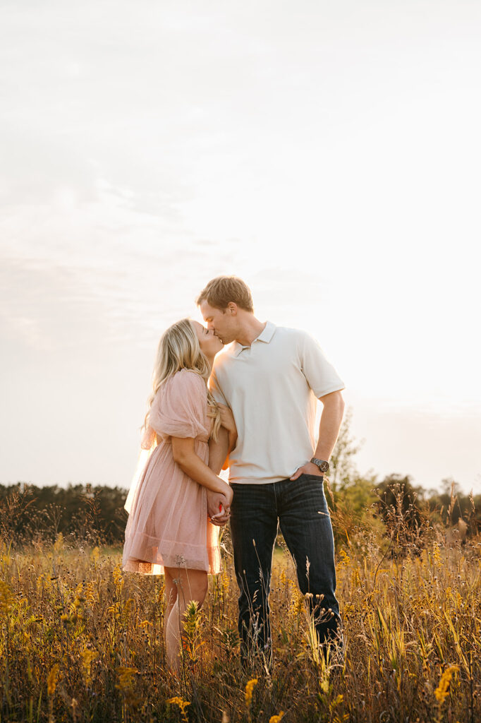Couple walking together amidst tall grasses for field engagement photos in Bemidji, MN