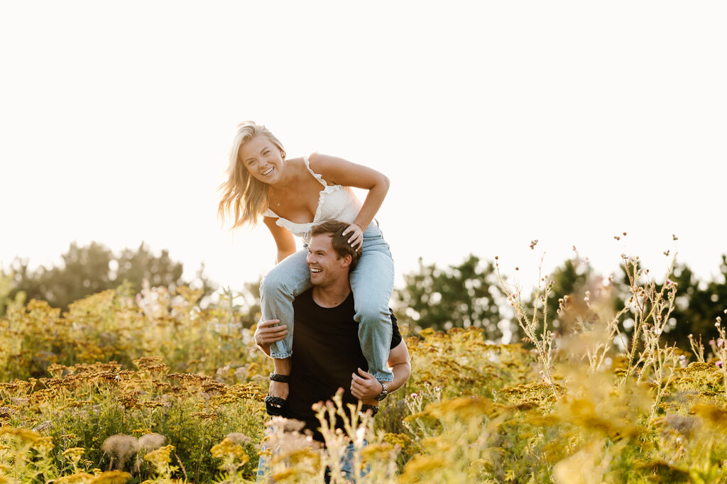 Engaged couple captured in a romantic setting among wildflowers in Bemidji