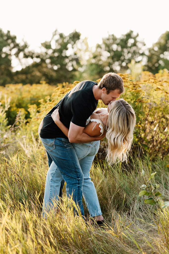 Field engagement photos showcasing a loving couple embracing among golden grasses
