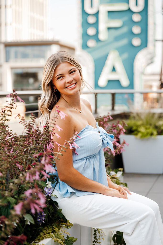 A girl posing for her senior photos, with downtown Fargo in the backdrop