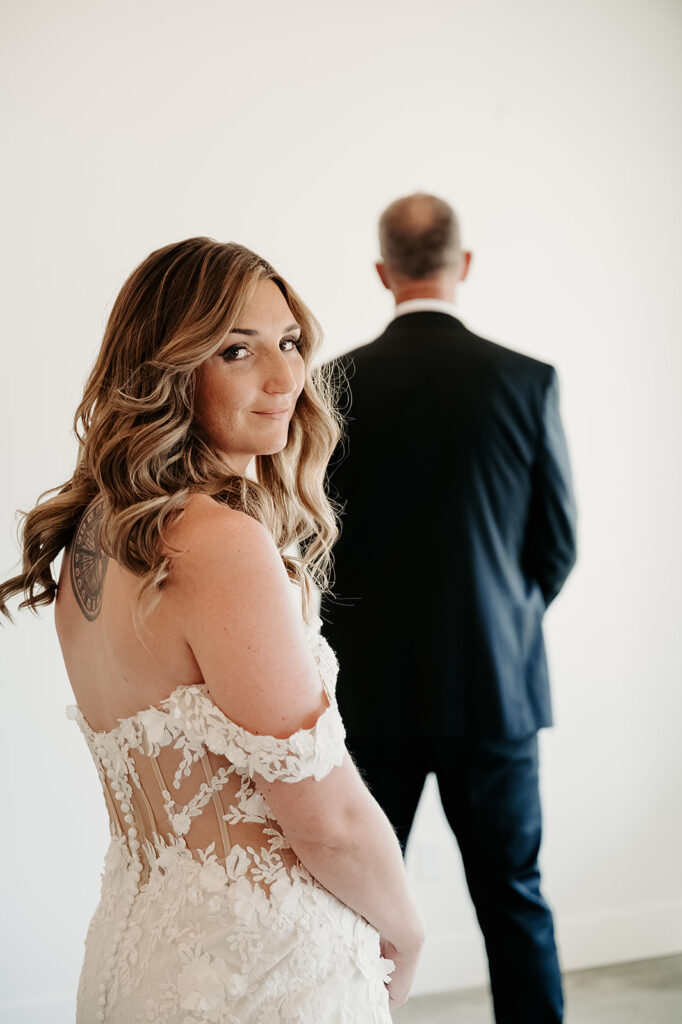 Emotional moment captured between the bride and her father during their first look at the Bluebelle Event Venue, with the bride in a stunning white gown and her father showing a tearful smile of joy.