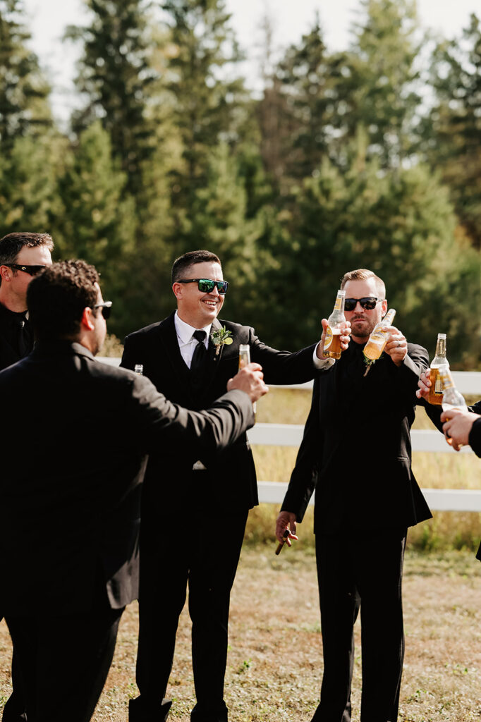 Lighthearted and fun photos of the groom and his groomsmen at the Bemidji wedding venue, all dressed sharply in suits, sharing laughs and candid moments