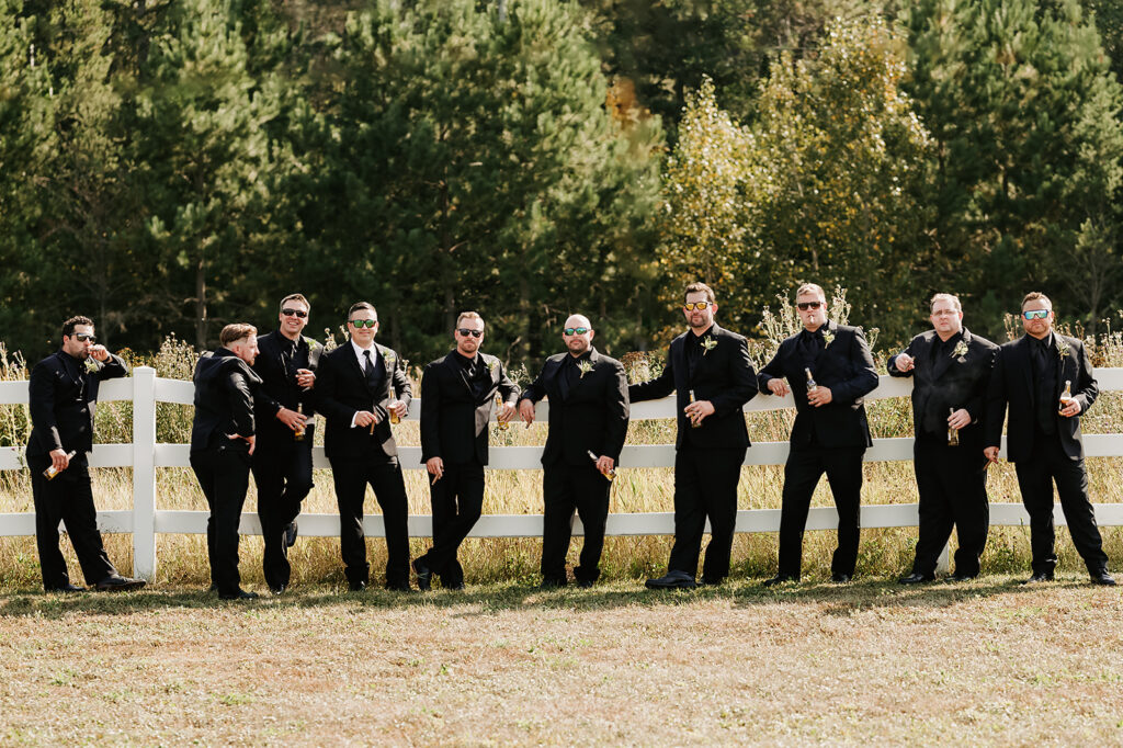 fun groomsmen photo outdoors with a lush forest in the backdrop