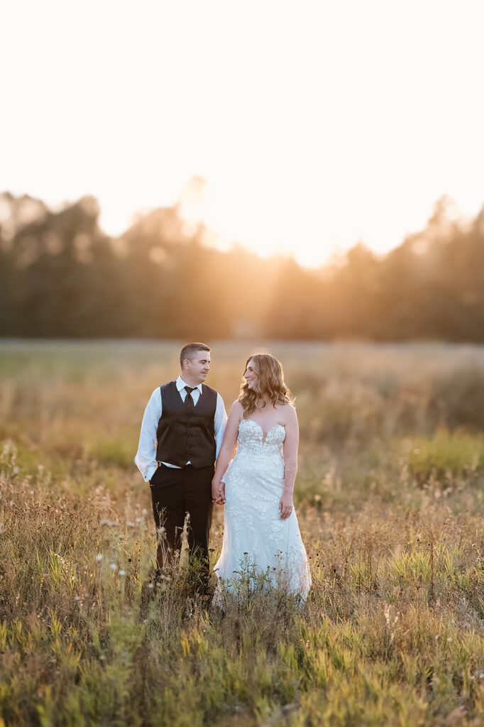Romantic golden hour photos of the bride and groom at the Bemidji wedding venue, with warm sunlight casting a soft glow on the couple as they embrace, surrounded by a picturesque natural setting