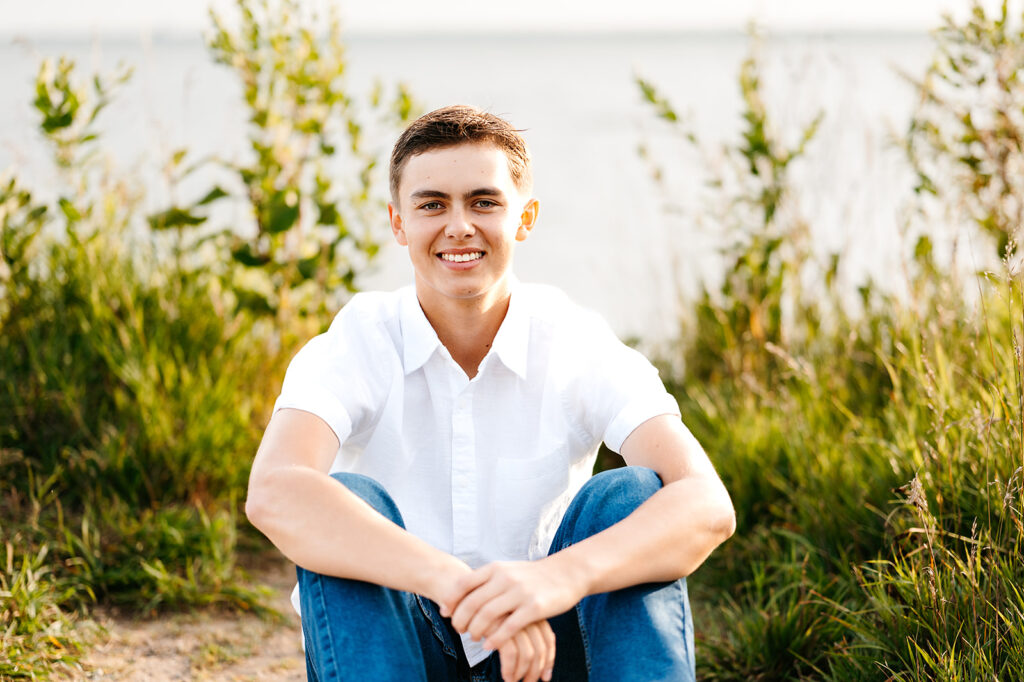 A senior photo capturing a boy student by the water