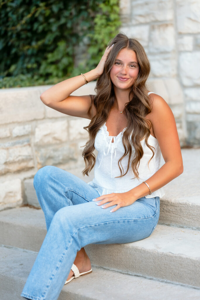 teen posing on the steps dressed in classy casual outfit for her urban senior portraits
