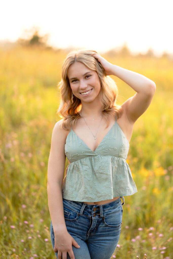 Senior photos in Minnesota featuring a girl enjoying golden hour in a lush wildflower field