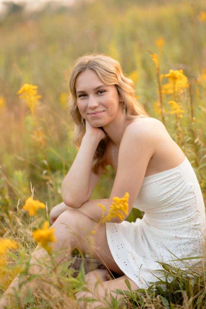 Senior photos in Minnesota featuring a girl enjoying golden hour in a lush wildflower field