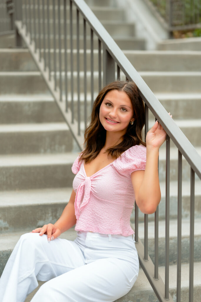 teen posing on the steps dressed in classy casual outfit for her urban senior portraits
