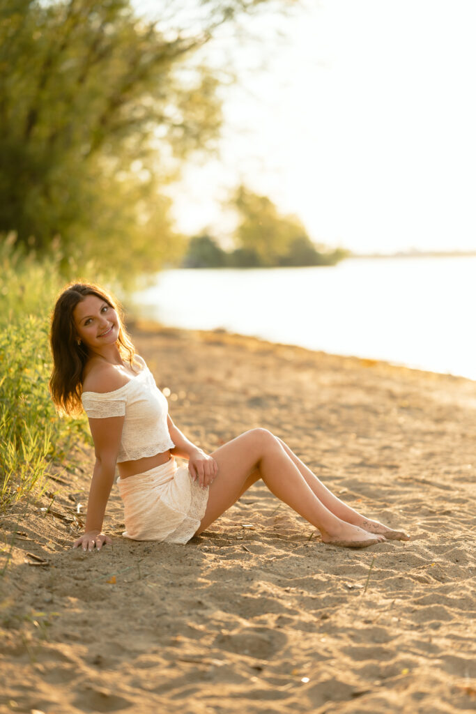 Girl sitting by the water at a like for her senior photos in Bemidji MN