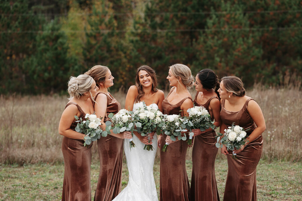 bride and bridesmaids posing in a field