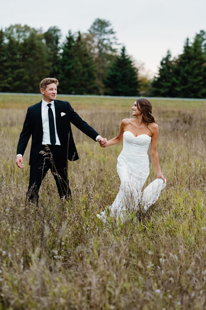 romantic and plaful bride and groom wedding portraits in a gorgeous, lush field
