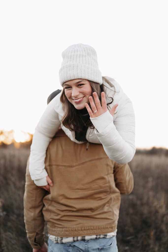 playful winter engagement photos where Cole has thrown Alexis over his shoulder