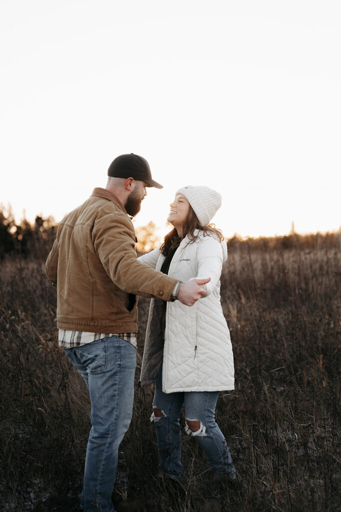 romantic and playful winter golden hour engagement photos in a gorgeous field in Minnesota