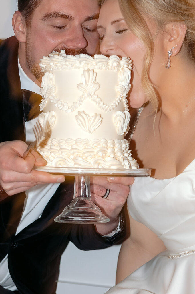 Bride and groom sitting on the floor eating cake together late at night at The Aisling