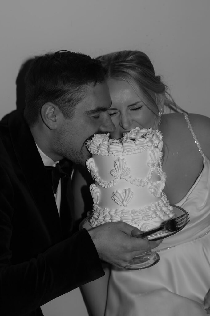 Bride and groom sitting on the floor eating cake together late at night at The Aisling
