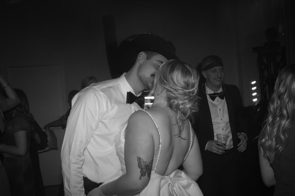 bride and groom kissing on the dance floor during their reception at the Aisling