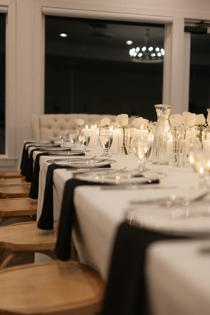 Elegant table setup with candles and white roses at The Aisling wedding reception