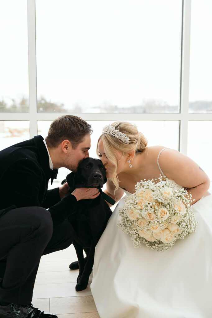 bride and groom snuggling their dog