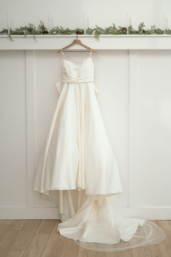 elegant wedding dress hanging at a wall