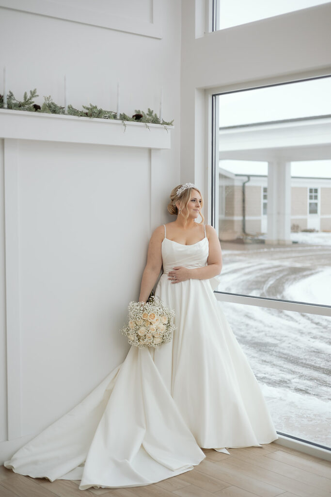 bridal portrait in front of the large windows at The Aisling during winter wedding