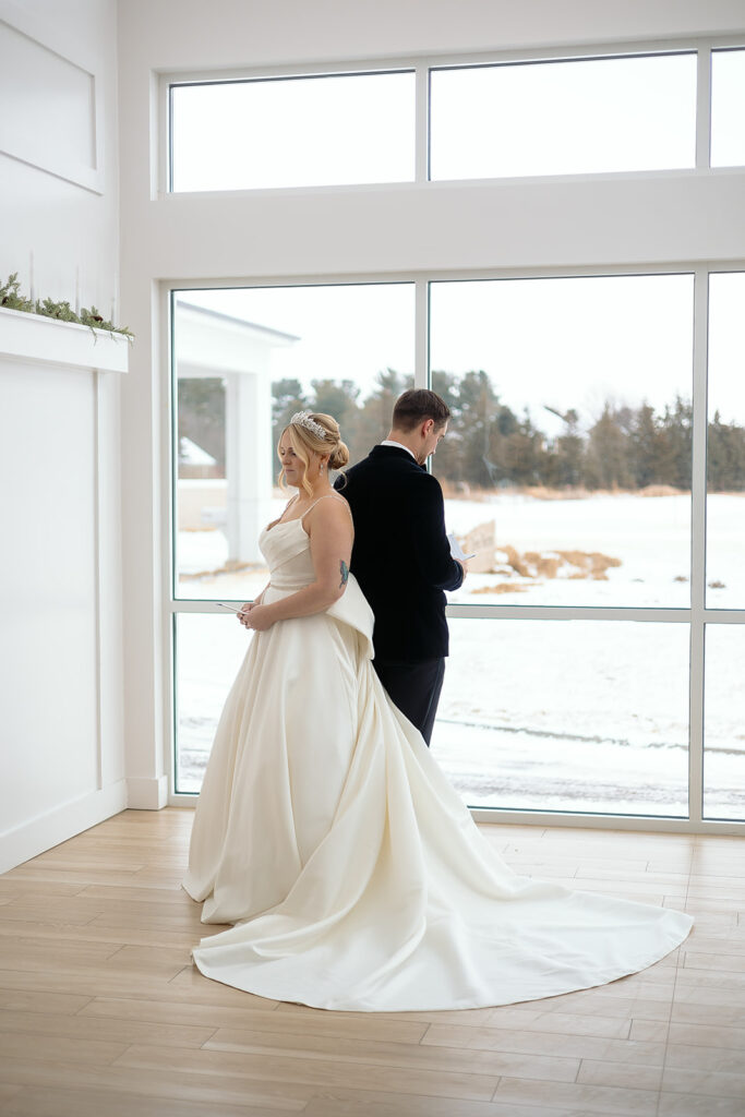 Bride and groom standing back-to-back for private vow reading at The Aisling wedding venue