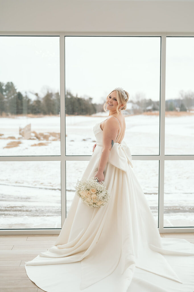Bridal portrait in front of the large windows at The Aisling during winter wedding