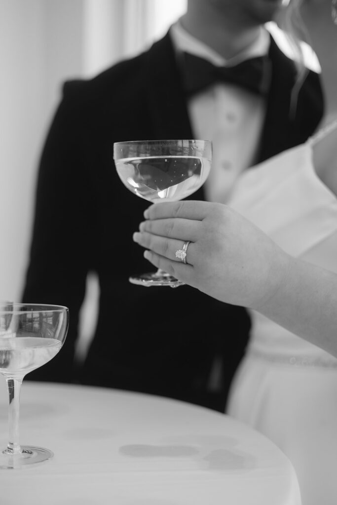 bride and groom drinking champagne next to their champagne tower