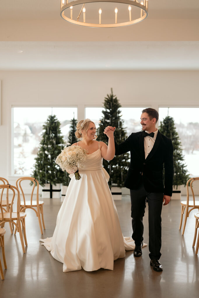 bride and groom holding hands at the indoor ceremony location at the Aisling