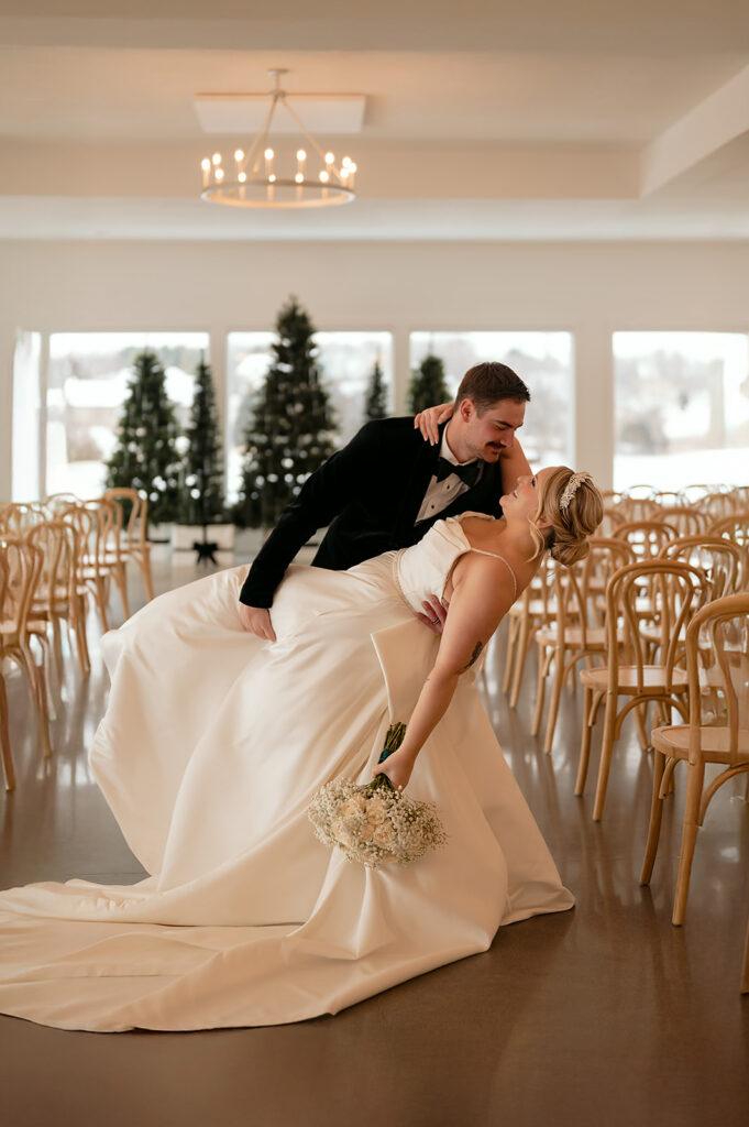 bride and groom dip kiss at the indoor ceremony location at the Aisling