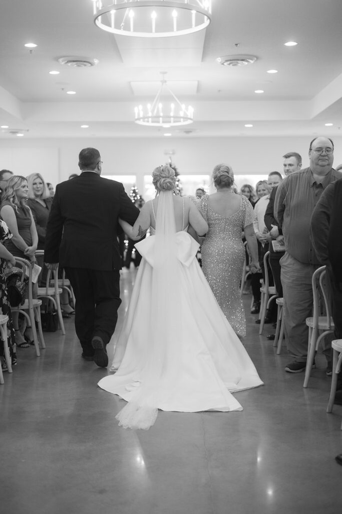 bride walking down the aisle with parents
