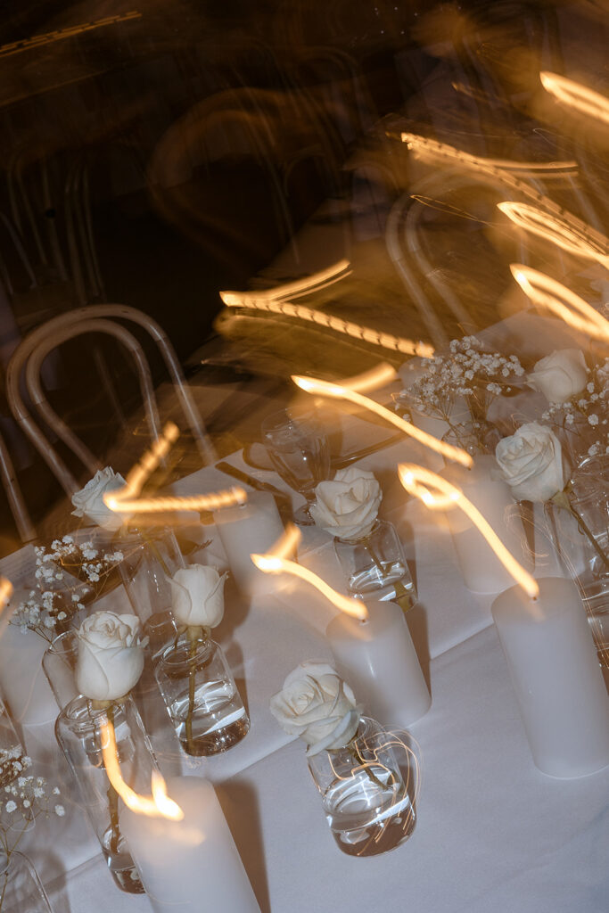 Elegant table setup with candles and white roses at The Aisling wedding reception