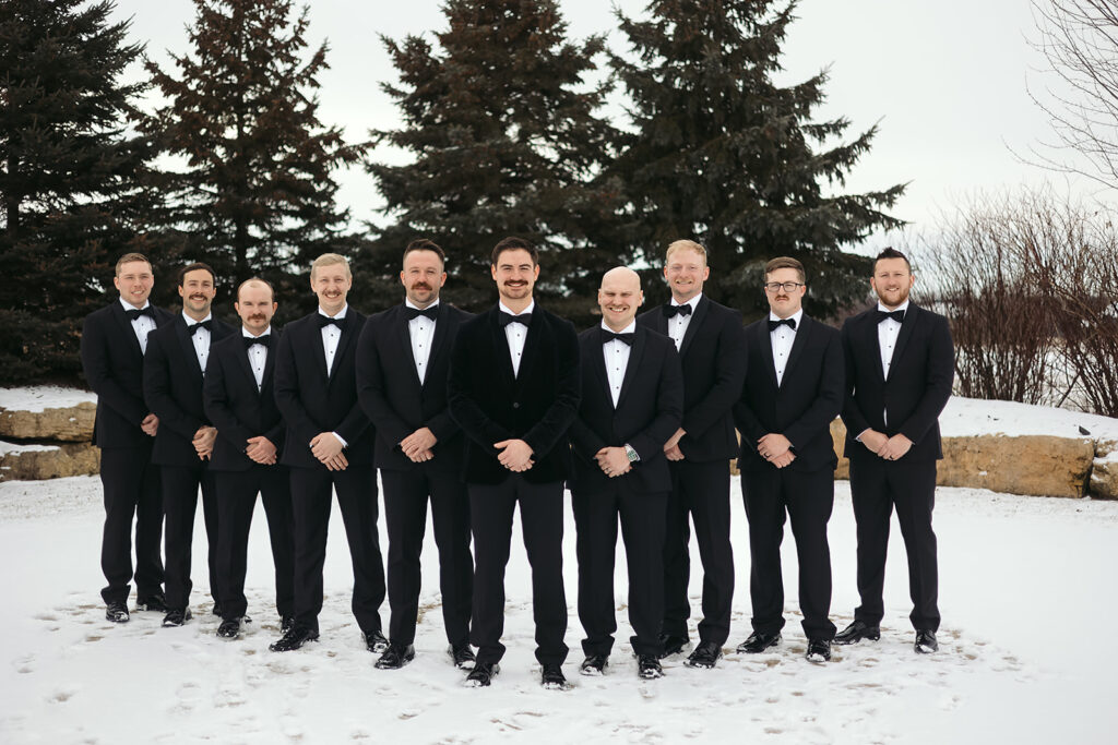 groom and groomsmen outdoors in the snow