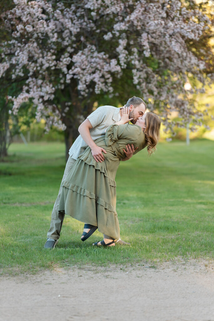 couple kissing with blooming crab trees in the backdrop