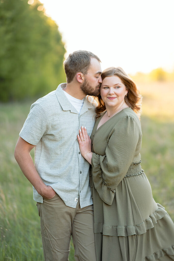 sweet couple in a field for their spring engagement photos