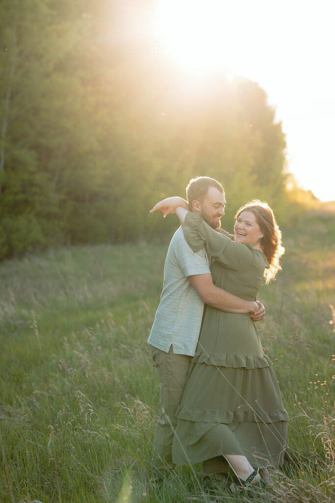 playful couple in a field during golden hour in Minnesota