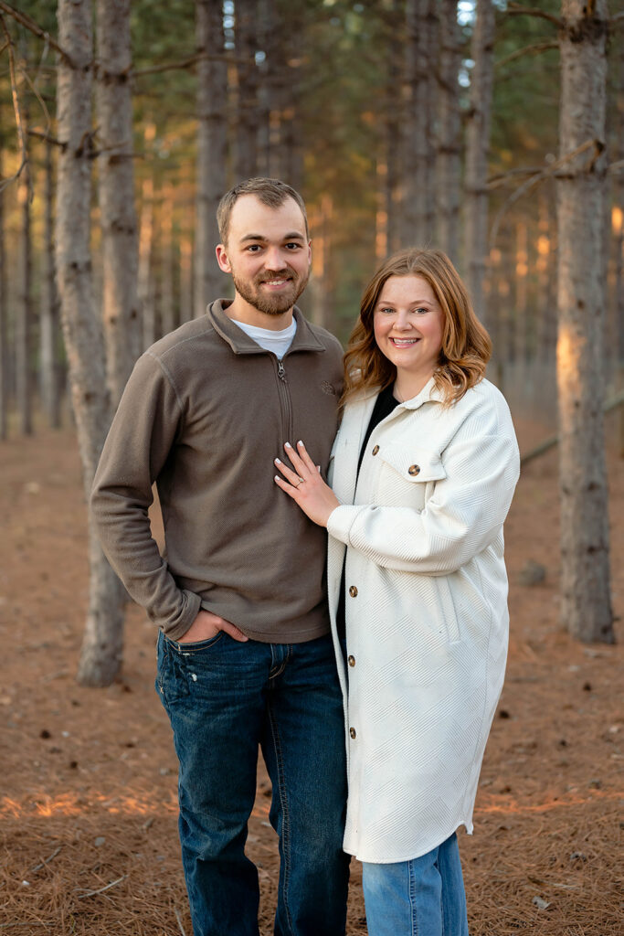 couple posing surrounded by trees in the forest