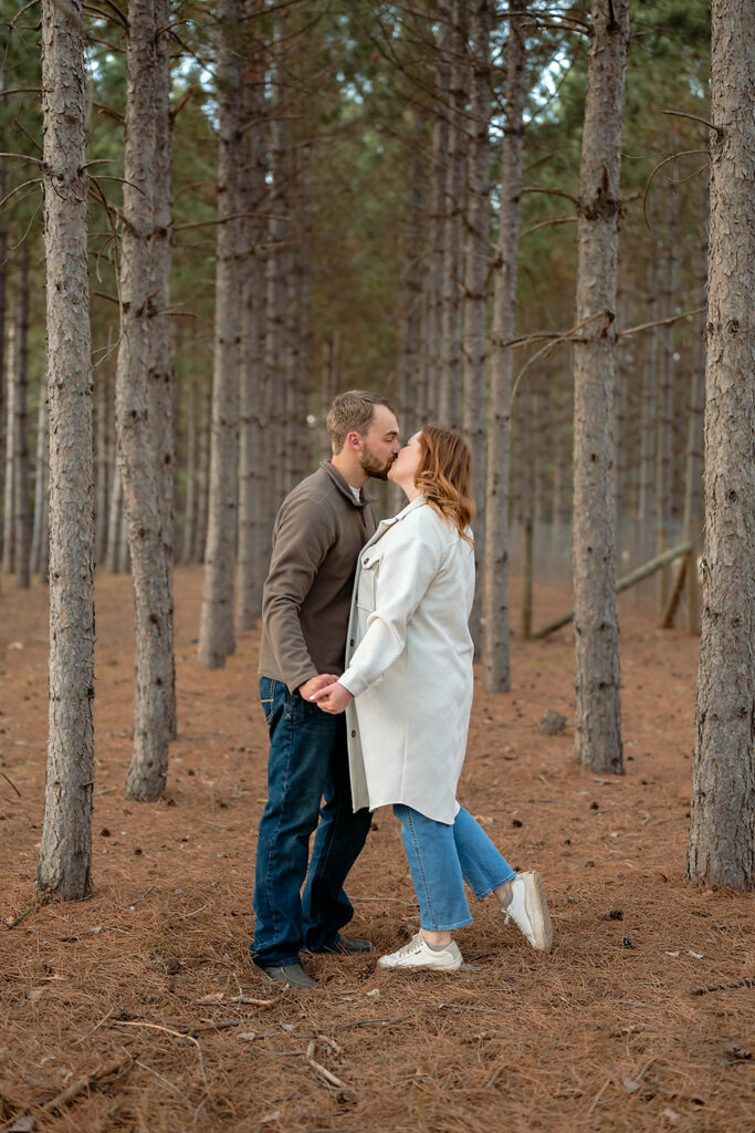 couple kissing in a forest 