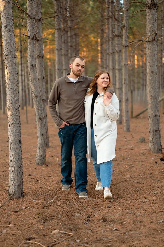 couple posing surrounded by trees in the forest