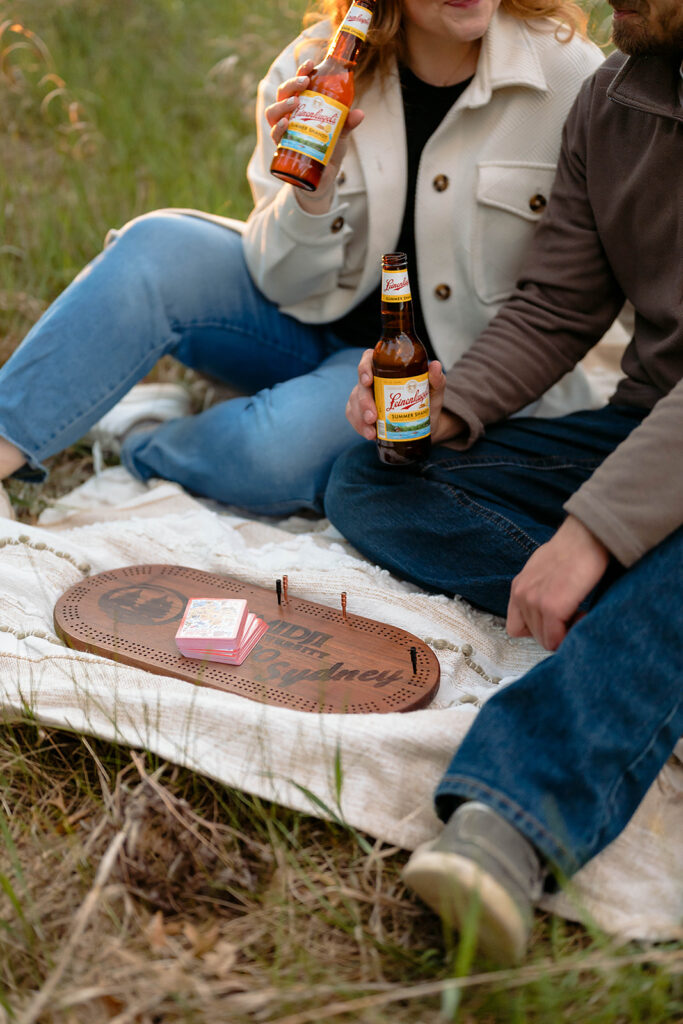couple having a picnic in a field for their minnesota spring engagement