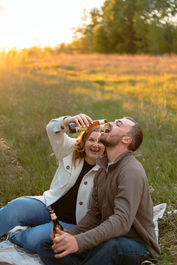 couple having drinks during their picnic engagement session