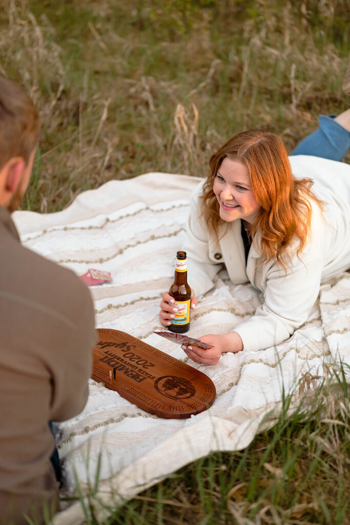 couple having a picnic and playing cribbage in a field in Minnesota