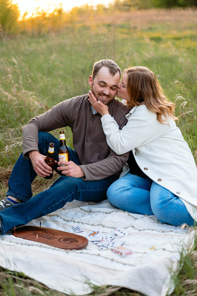 couple having a picnic in a field for their minnesota spring engagement